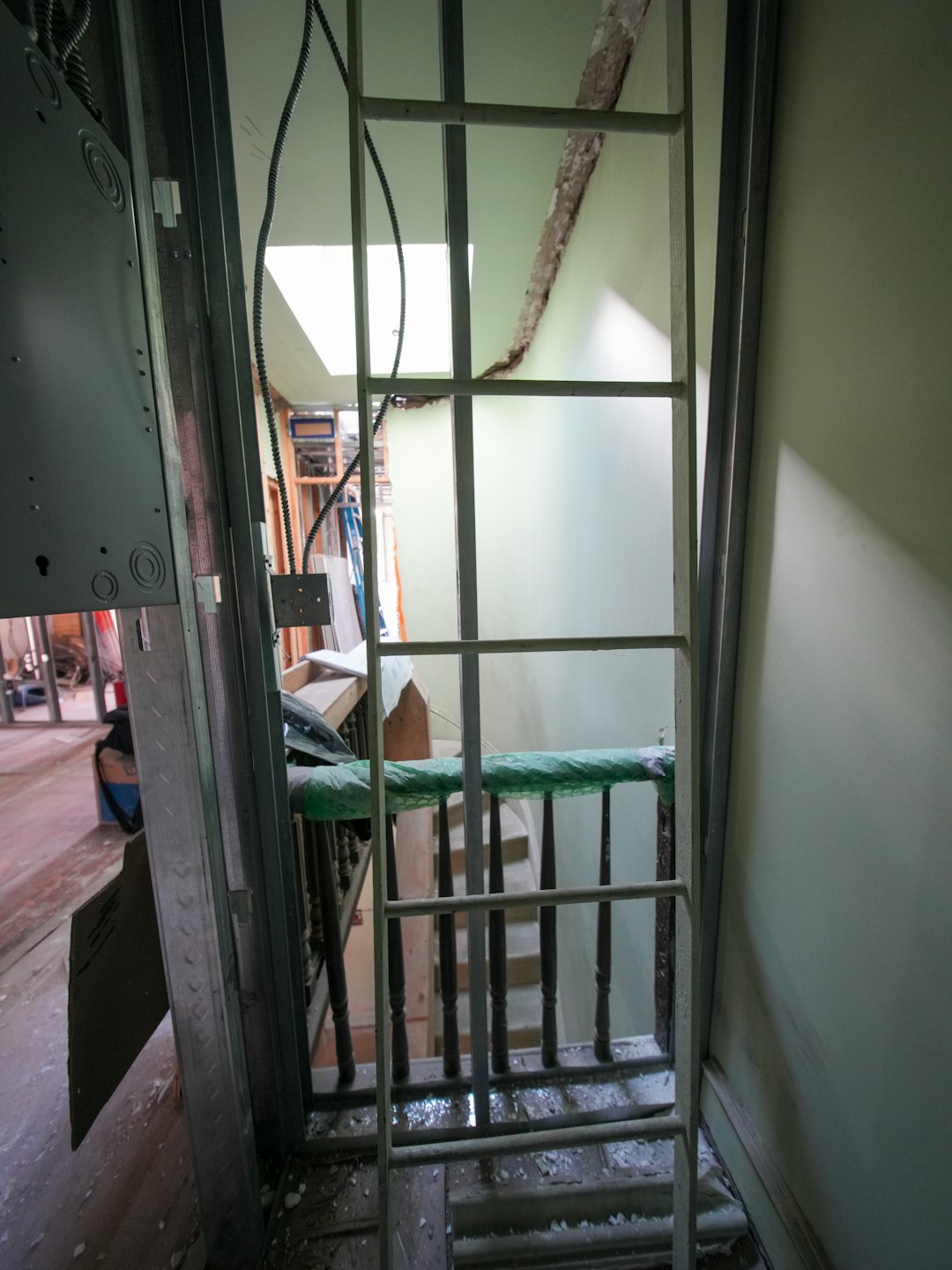 A three-story brownstone stands in mid-transformation, captured at the raw and honest “before” stage of a full interior renovation. These images document a moment that usually disappears once the walls are closed and the finishes are installed — exposed framing, stripped ceilings, rough staircases, and open corridors that reveal the building’s original structure and hidden history. Light spills in through skylights and tall windows, cutting through layers of dust and unfinished surfaces, creating a quiet contrast between decay and renewal. The space feels both industrial and intimate: narrow